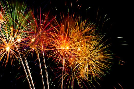 Colorful fireworks explode in the night sky, creating a vivid display of light and color.
